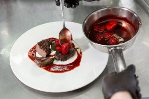 Chef decorates the meat with strawberries.